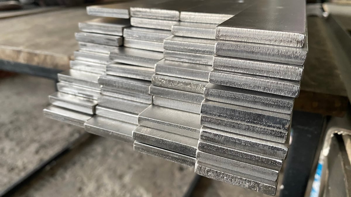 Stacked stainless steel flat bar ready for fabrication in the workshop