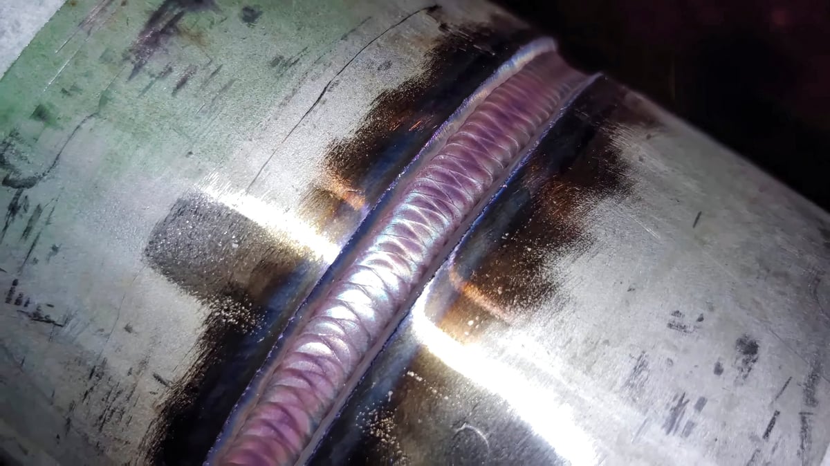 Close inspection of a weld bead detail on an industrial stainless pipe for quality control